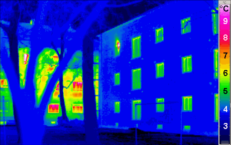 Termogram dwóch budynków wielorodzinnych: ocieplony (zimna, niebieska elewacja) obok nieocieplonego (ciepła, żółto-czerwona)